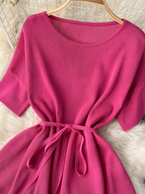 Pink knit tied waist two-piece set with wide leg pants and short sleeves.