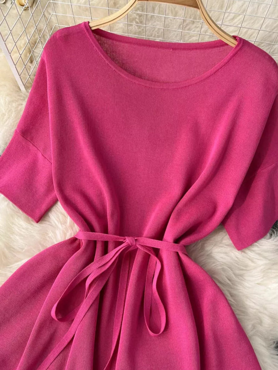 Pink knit tied waist two-piece set with wide leg pants and short sleeves.