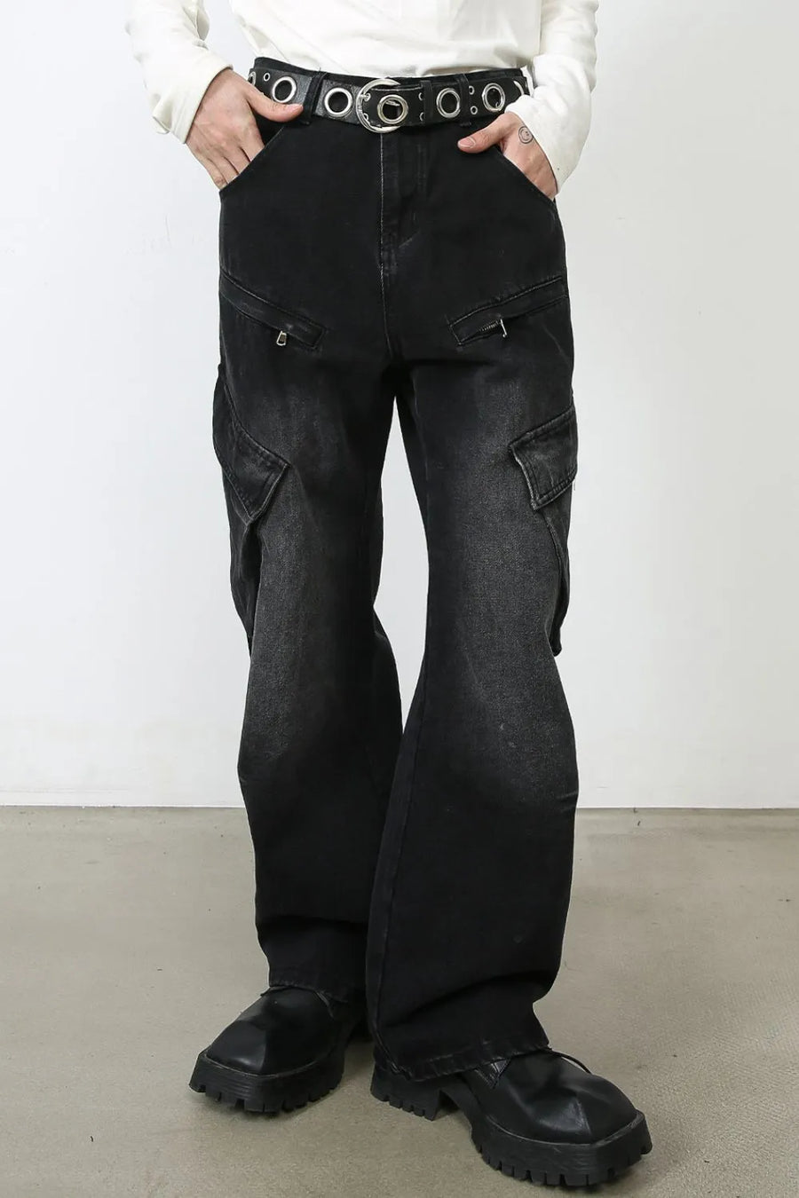 Faded black denim cargo pants with utility pockets and a wide leg.
