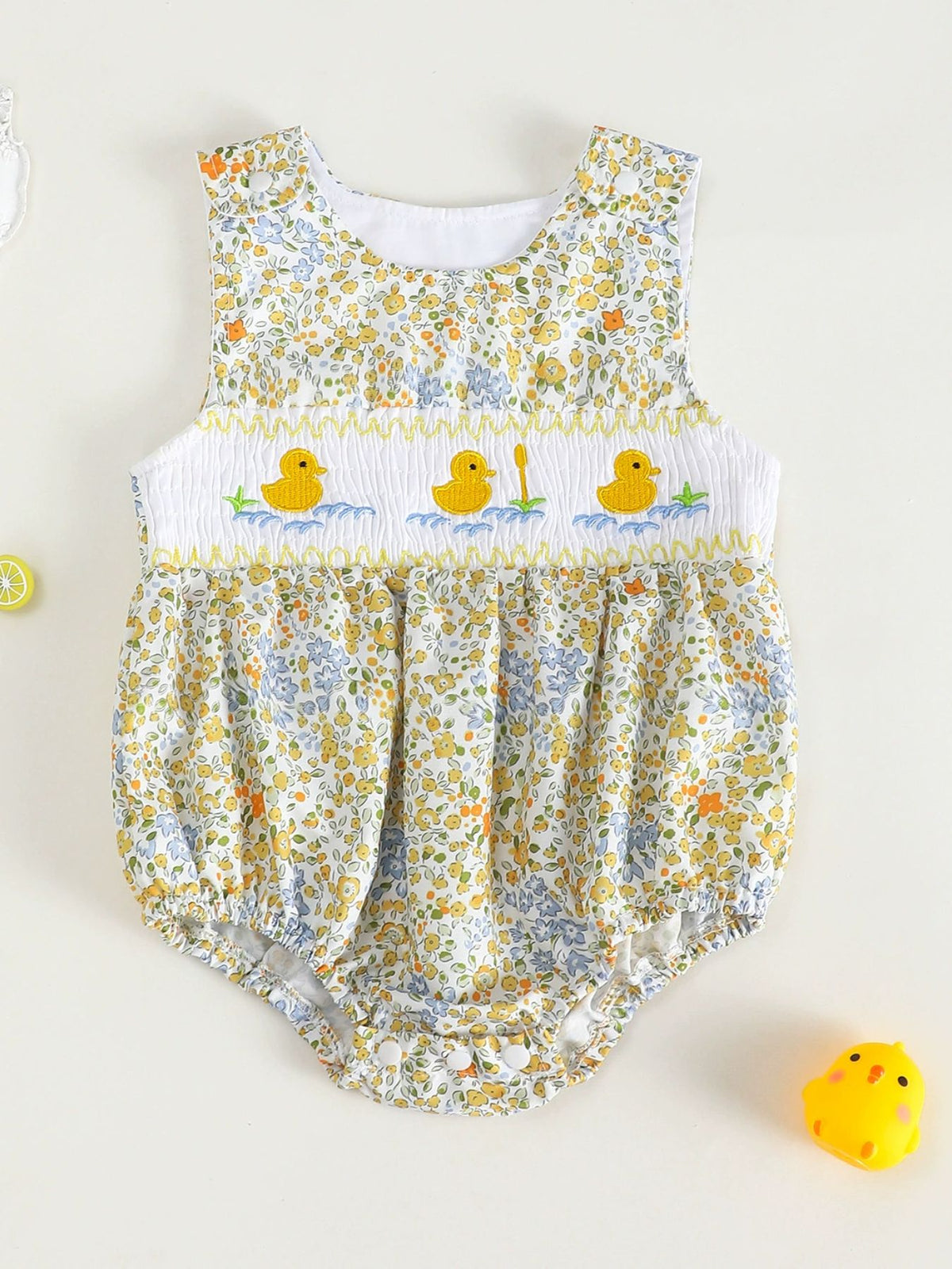 Baby floral one-piece with smocked chest and embroidered ducks.