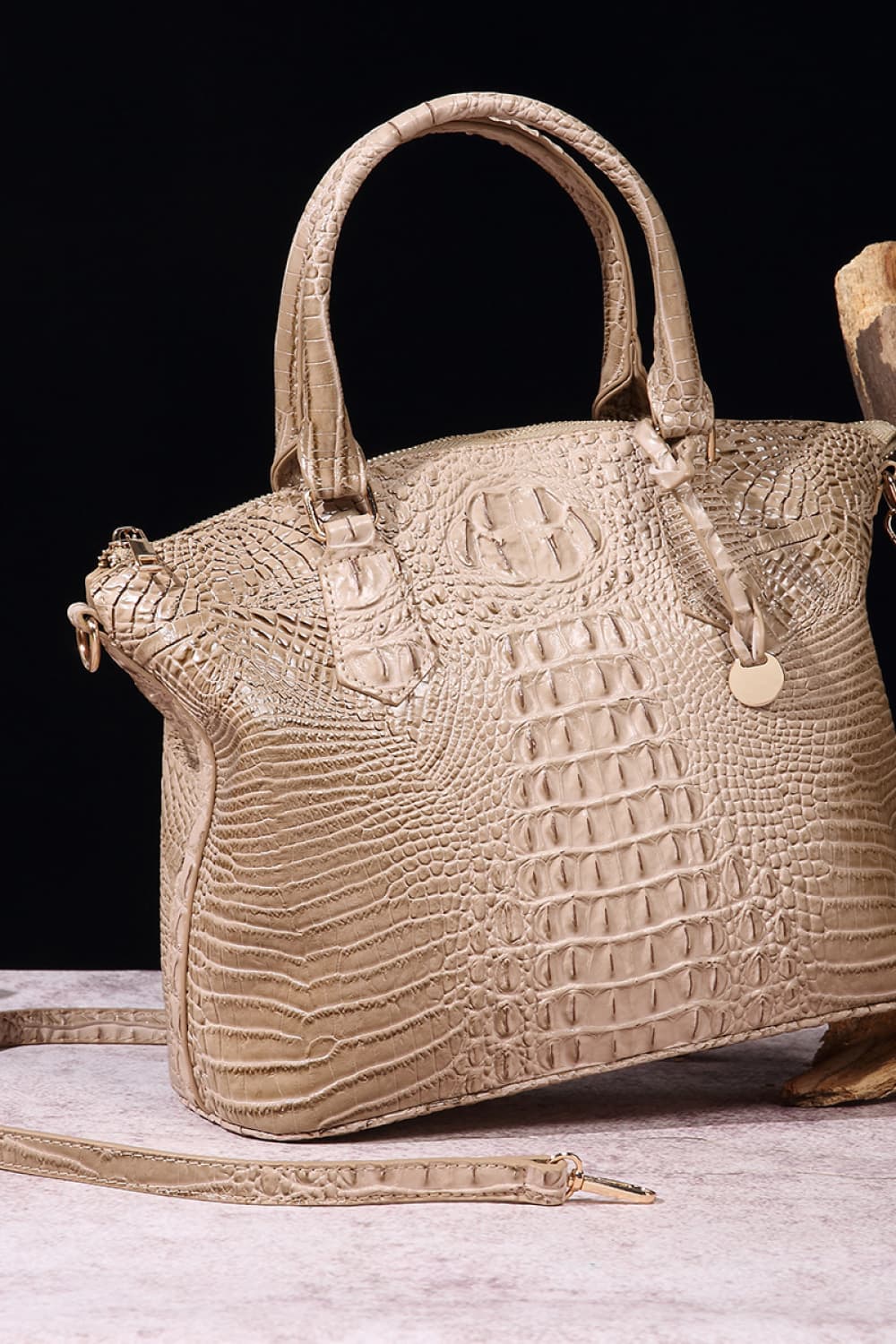 Taupe crocodile embossed satchel bag with top handle and detachable strap.