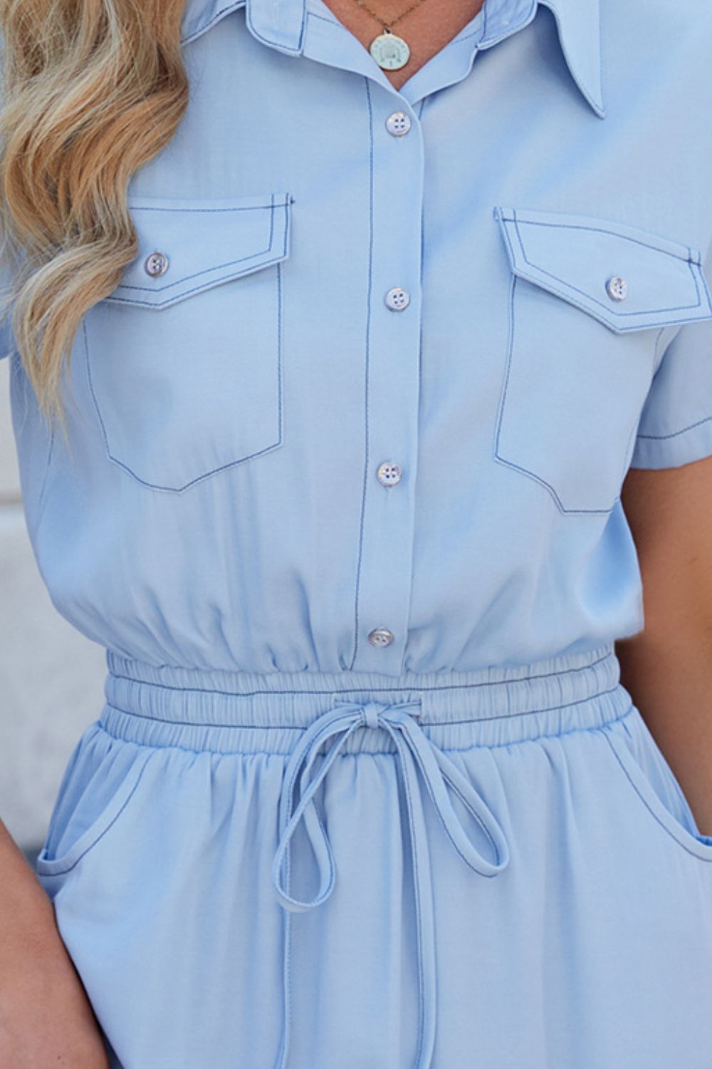 Light blue shirtdress with drawstring waist, collared, short sleeves, and chest pockets.