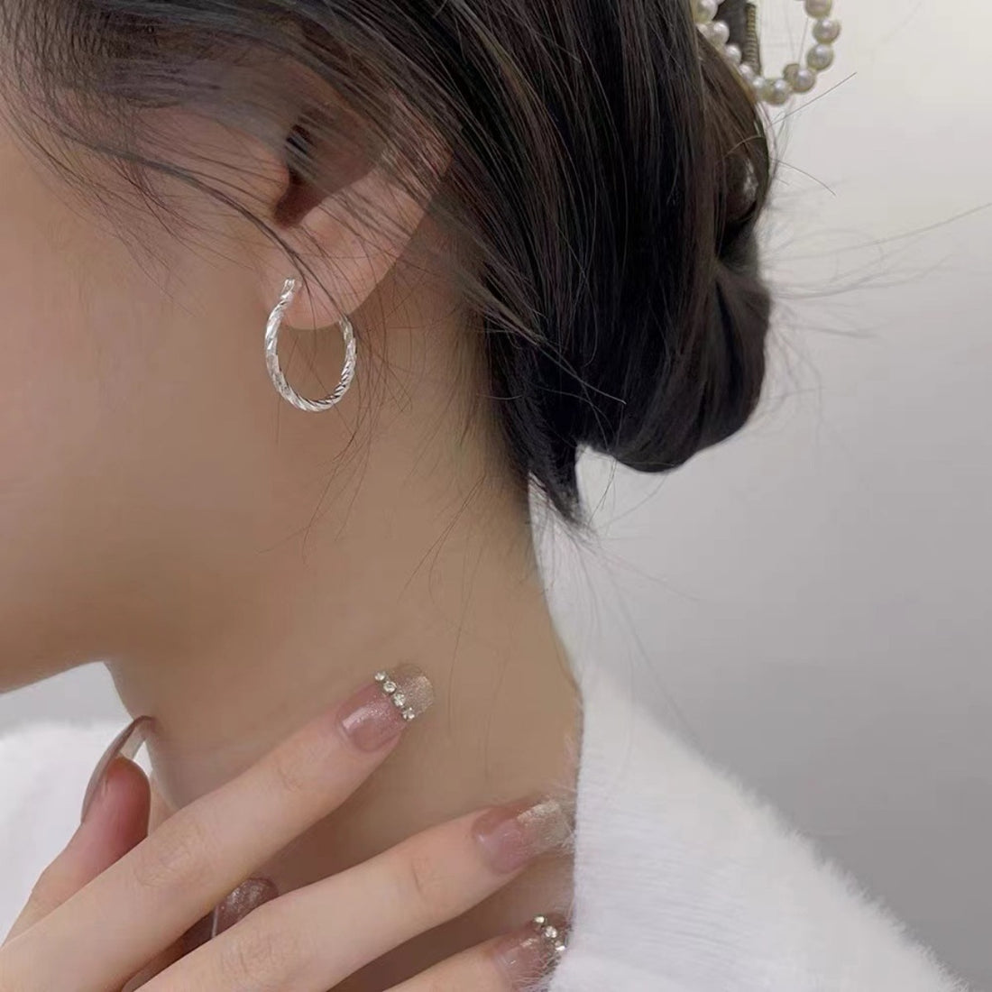 earrings in silver featuring twisted design and hoop fit