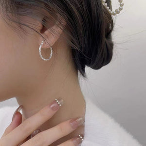 earrings in silver featuring twisted design and hoop fit