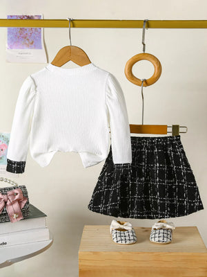 White ribbed long sleeve top with black cuff detail and black plaid skirt set