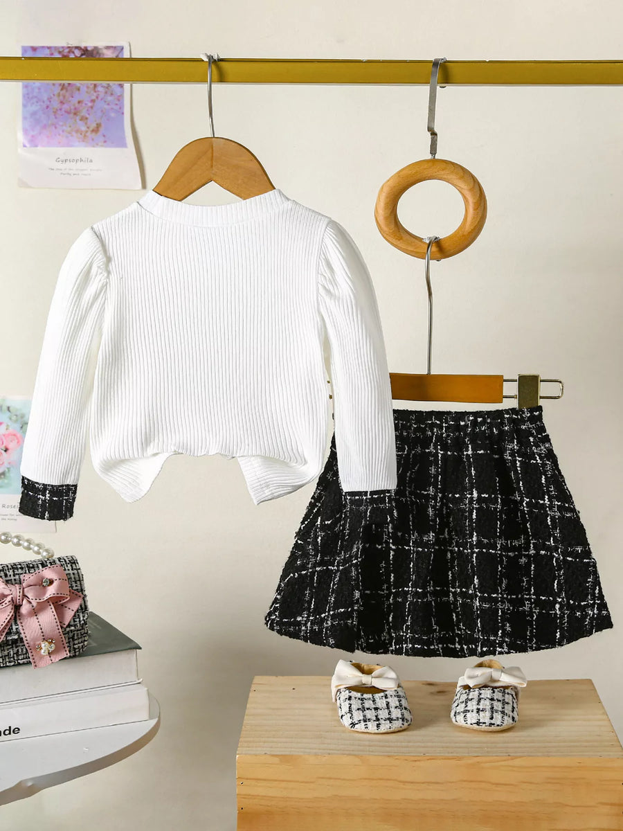 White ribbed long sleeve top with black cuff detail and black plaid skirt set