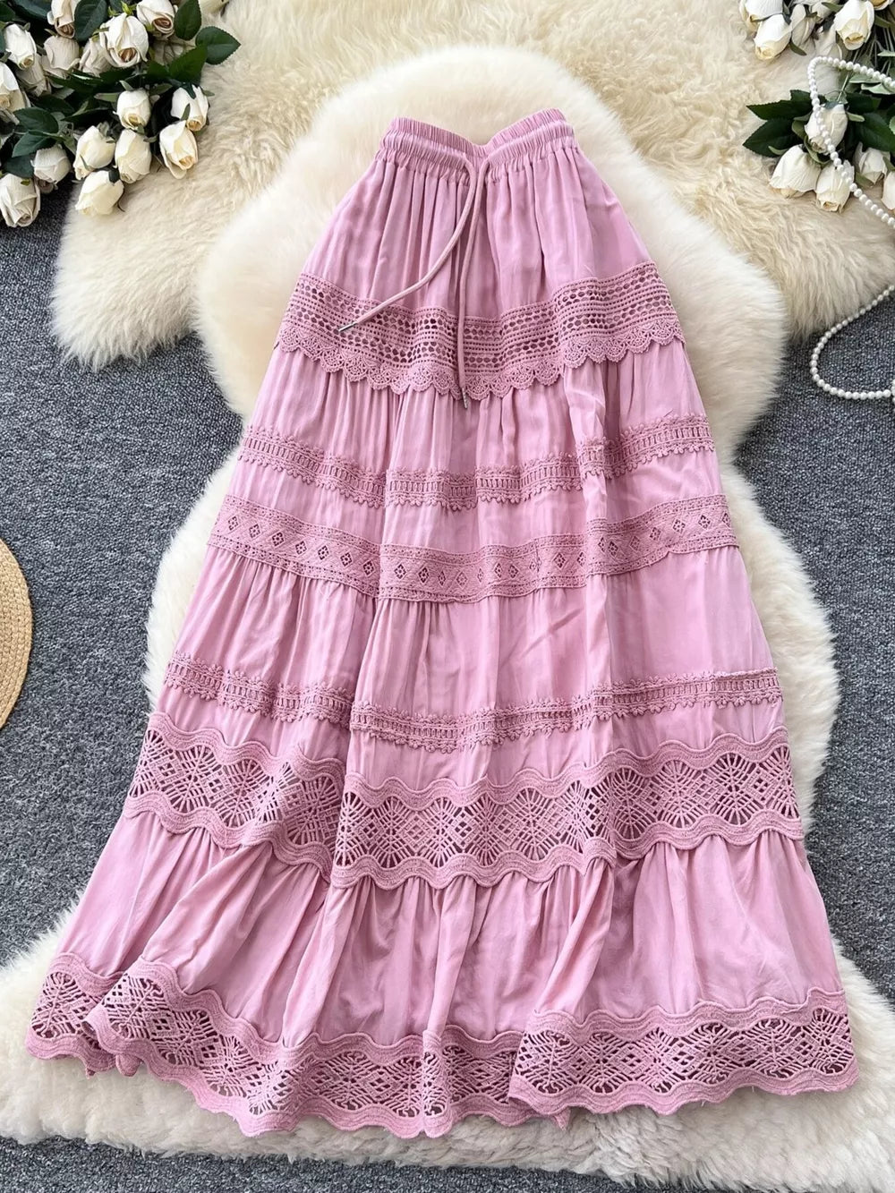 Pink tiered maxi skirt with lace trim and drawstring waist.