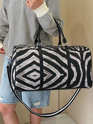 Bold zebra print duffle bag with black carry handles and detachable strap.