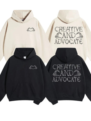 Black and beige oversized hoodies with embroidered skeleton hands forming a heart on the front and text on the back.