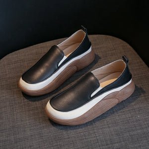 Black slip-on sneakers with white and brown platform soles