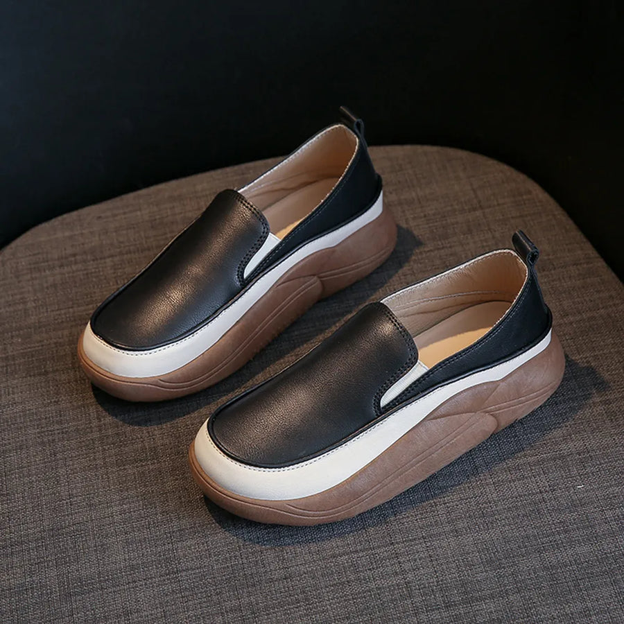 Black slip-on sneakers with white and brown platform soles