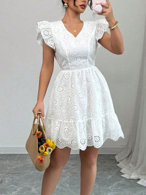 White eyelet mini dress with ruffle sleeves and tiered hem, V-neck, backless detail.