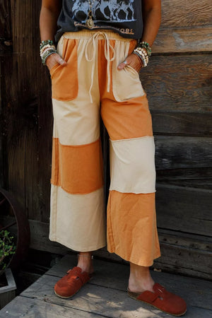 cream wide-leg pants featuring drawstring waist and color-block