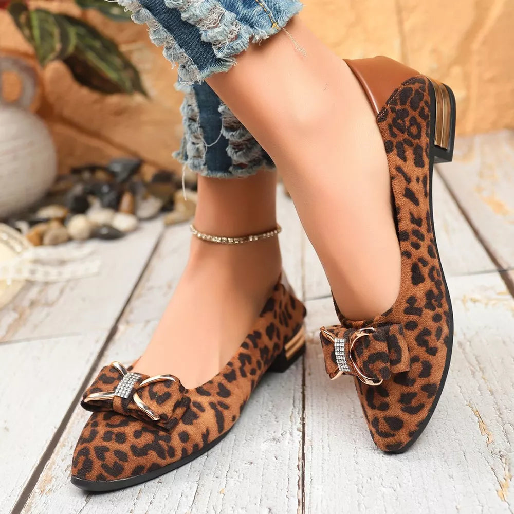 Leopard print pointed-toe block heels with a bow detail and gold accents.