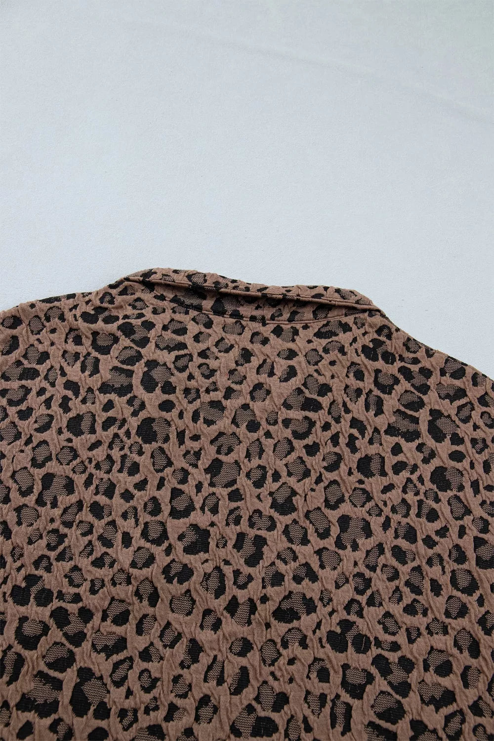 Brown leopard jacquard textured half-zip shirt with a collar.