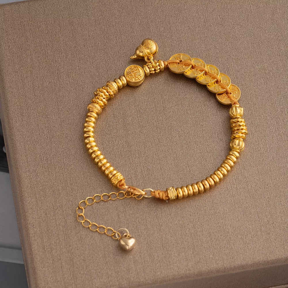 bracelet in gold featuring coin charms and chain fit