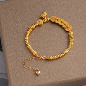 bracelet in gold featuring coin charms and chain fit
