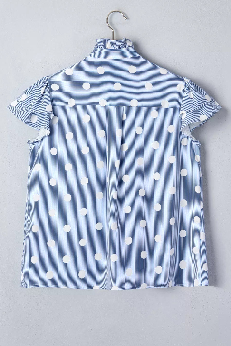 Blue and white striped and polka dot ruffled shirt with button-down detail.