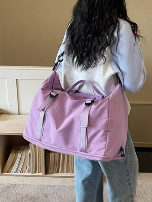 Spacious purple nylon travel bag with buckle straps and adjustable shoulder strap.