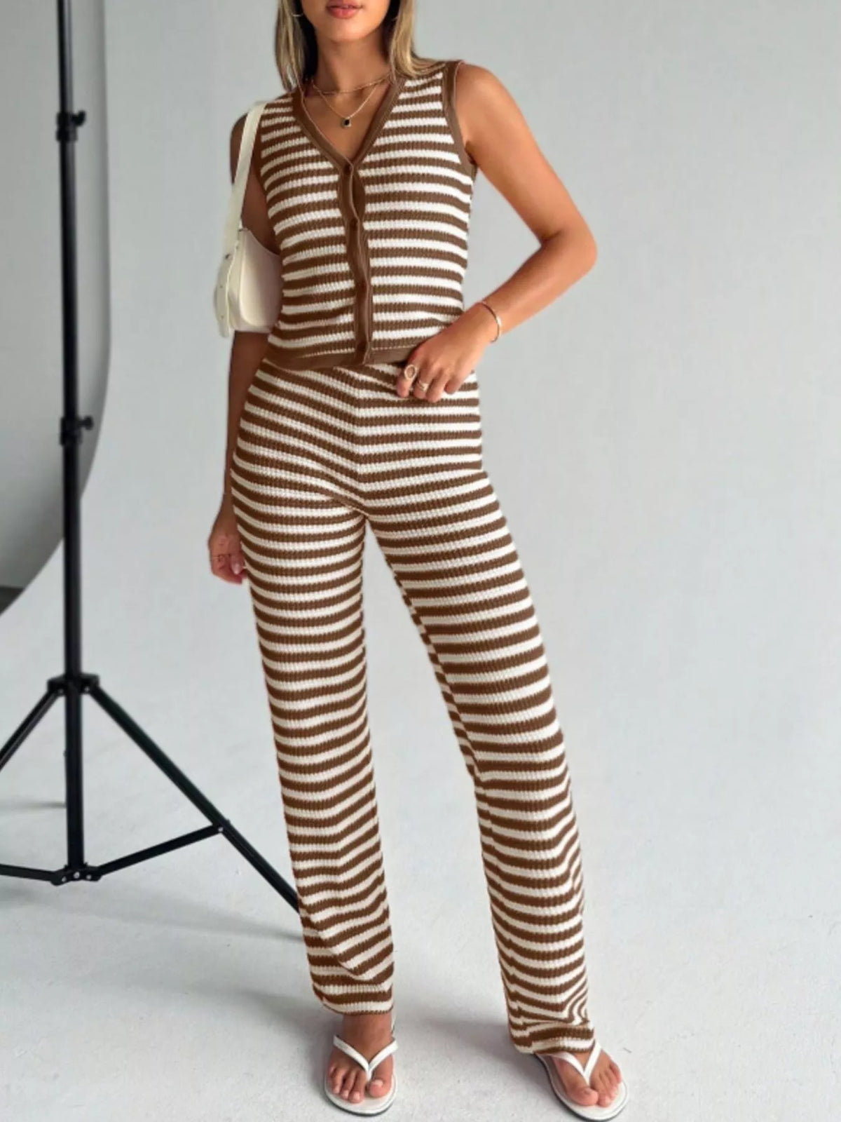 Brown and white striped knit two-piece set with buttoned sleeveless top and wide-leg pants.
