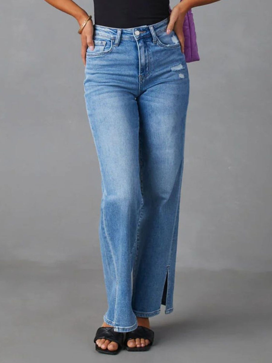 Medium wash split hem flare jeans with distressed details and a button closure.