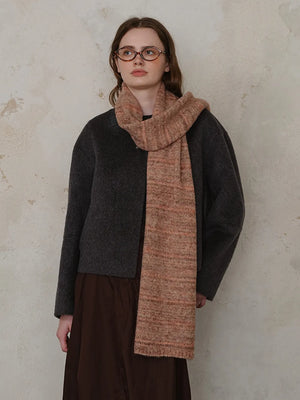 Textured mélange knit scarf in Terracotta with fringed ends, styled by a model.