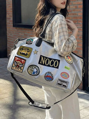 Metallic patchwork travel bag with textured finish and embroidered patches.