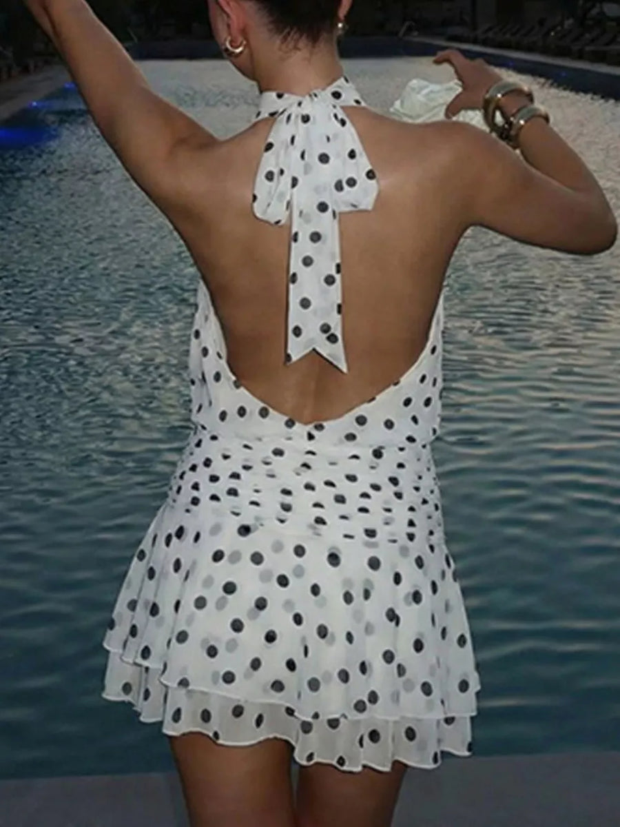 White polka dot halter neck mini dress with ruffled hem and open back.