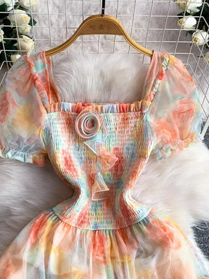 Floral tiered midi dress in sherbet with smocked bodice and sheer puff sleeves.