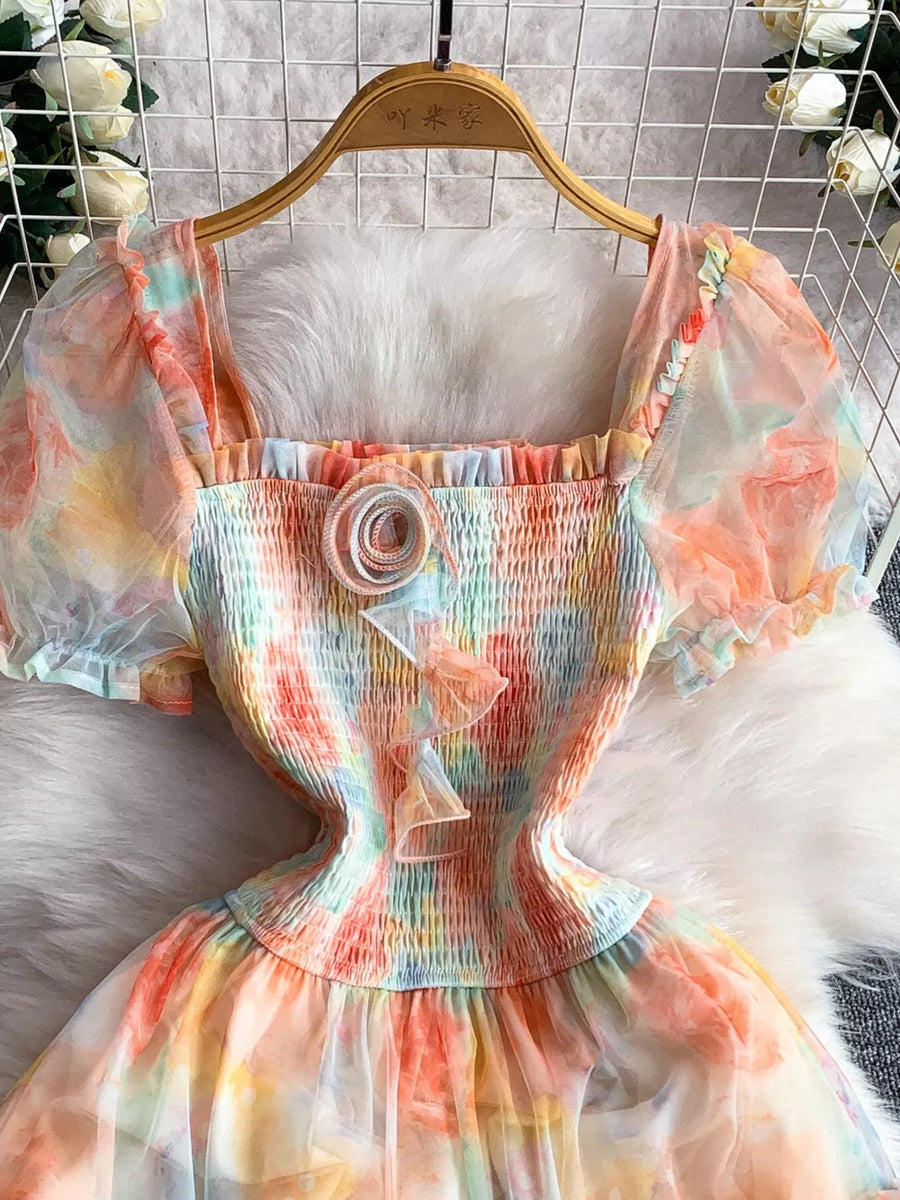 Floral tiered midi dress in sherbet with smocked bodice and sheer puff sleeves.