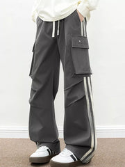 Oversized dark gray cargo pants with flap pockets and side stripes.