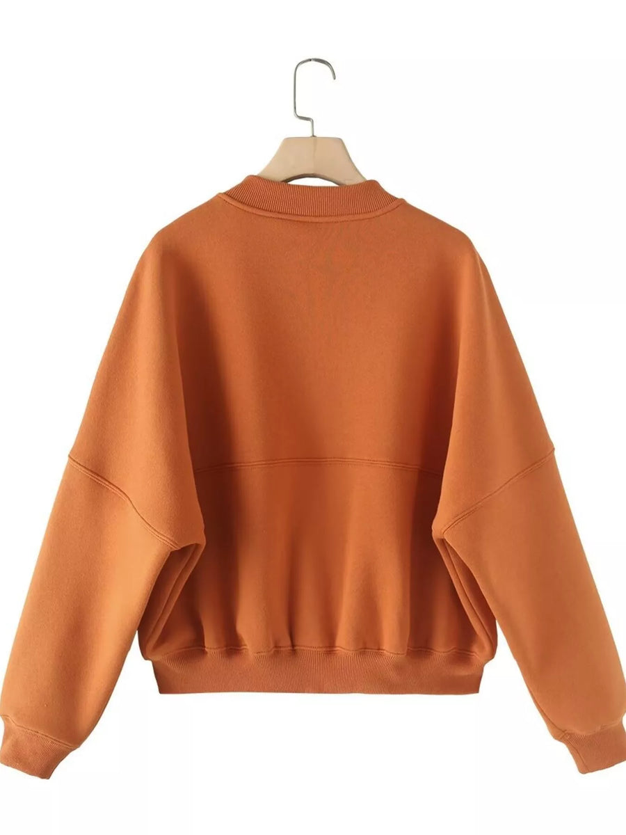 Orange casual zip-up top with wide sleeves and ribbed cuffs and hem.