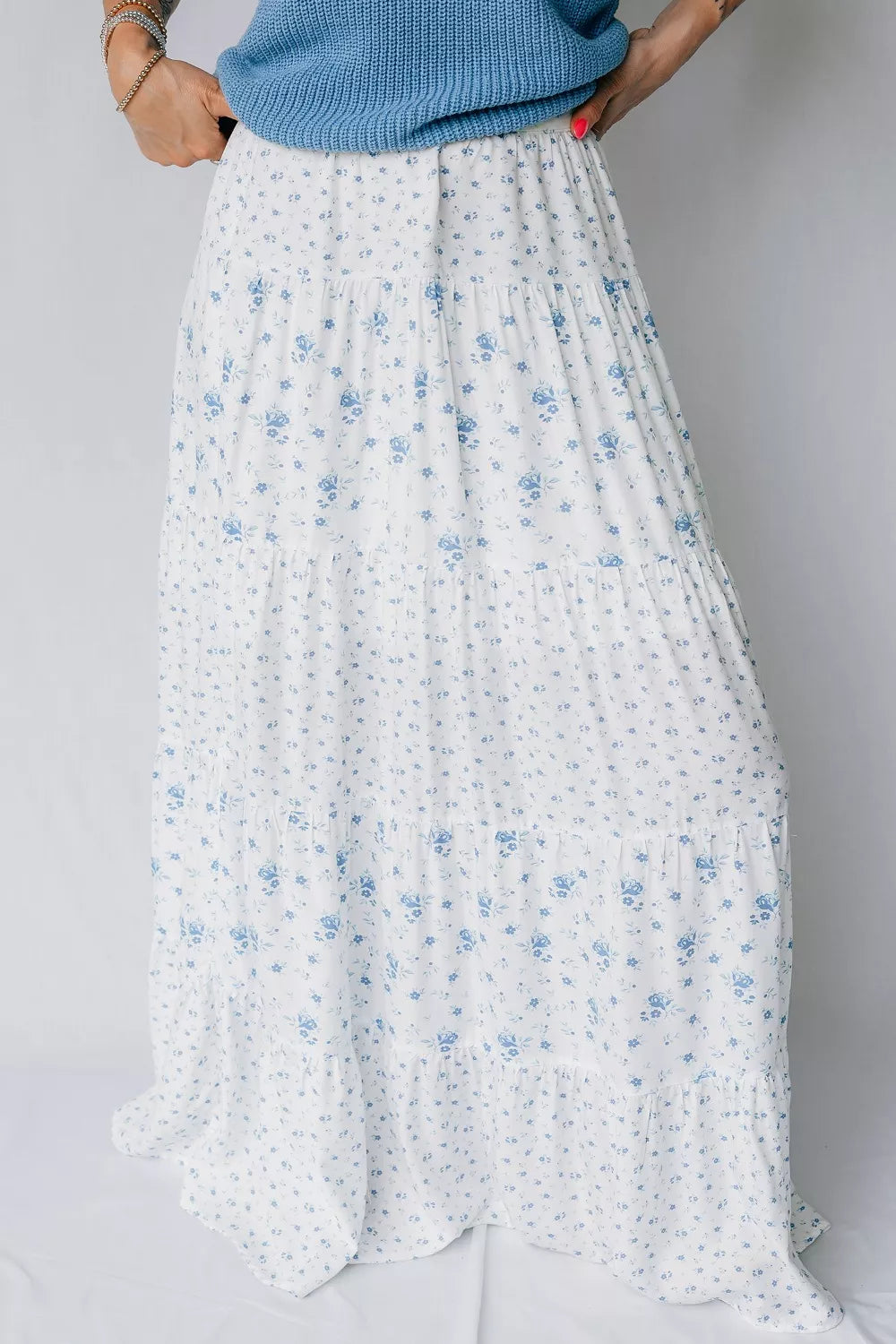 Bohemian tiered maxi skirt with a blue floral print on white fabric.