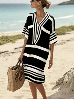 Black and white striped midi dress with half sleeves and V-neck, worn on the beach.
