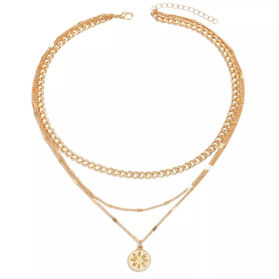 Gold layered necklace with delicate chains and a sunburst pendant.