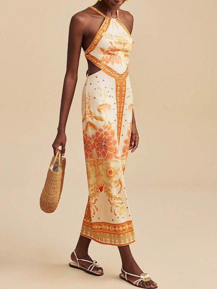 Backless maxi dress with orange floral print, halter neck, and side cutouts.