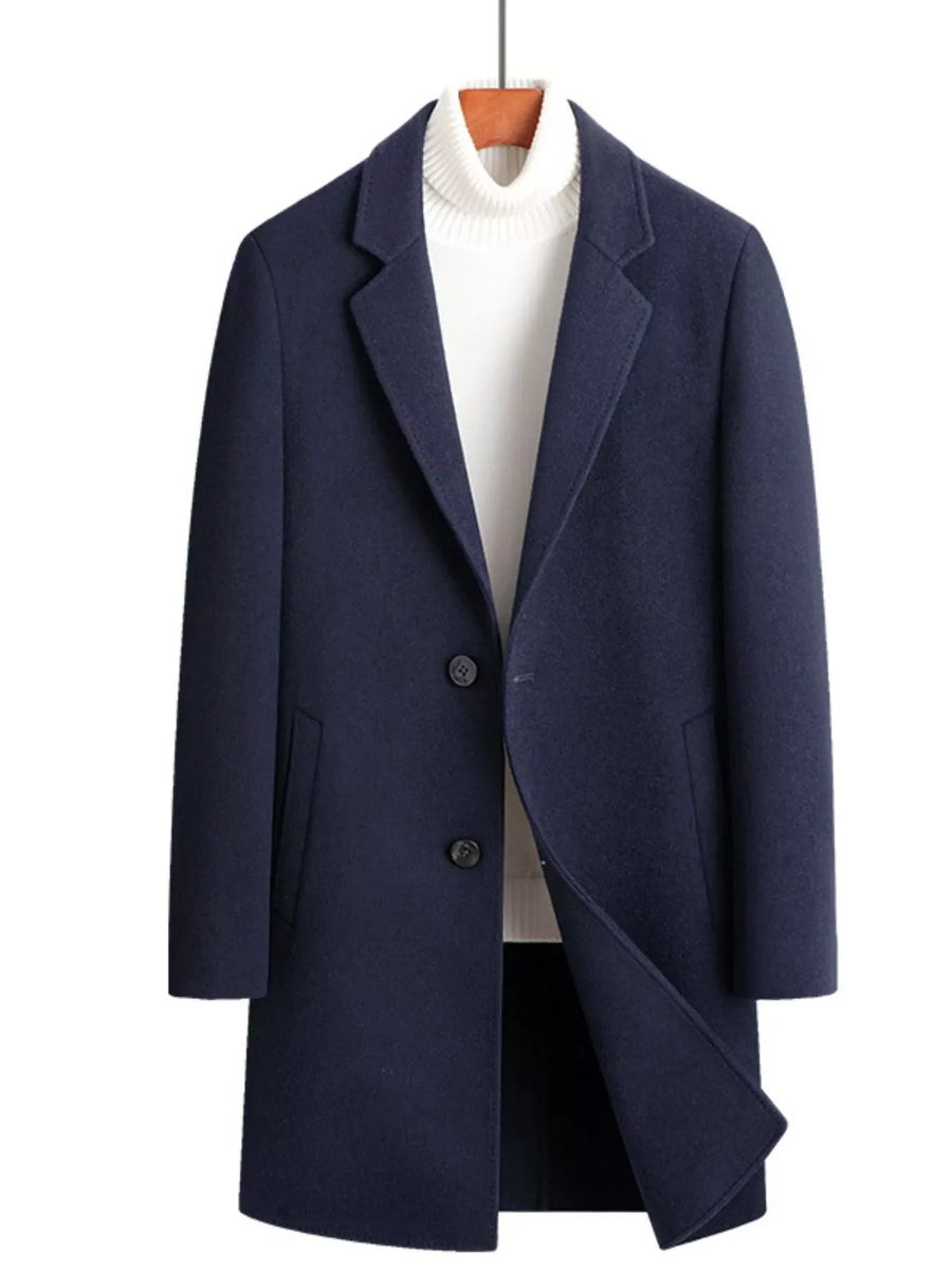 Men's navy blue wool blend overcoat with button closure and lapel collar, styled with a white turtleneck.