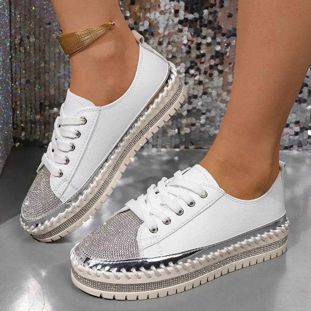 White sneakers with rhinestone toe caps and chunky soles.