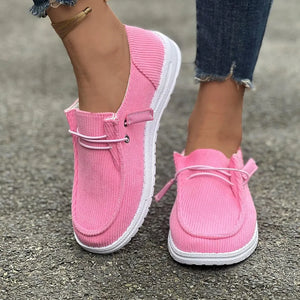 Pink corduroy boat shoes with lace detail and white soles.