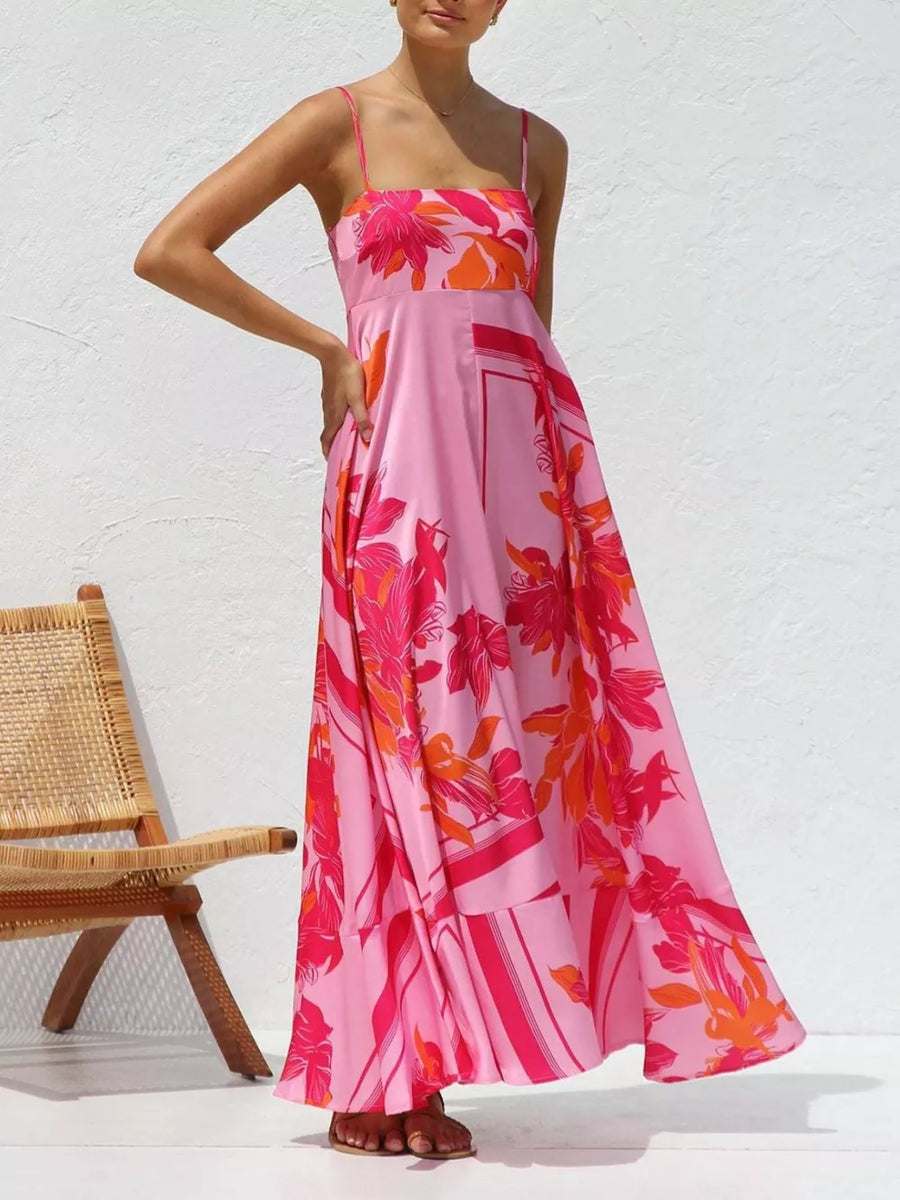 Maxi dress with spaghetti straps and a vibrant floral print in pink and orange.