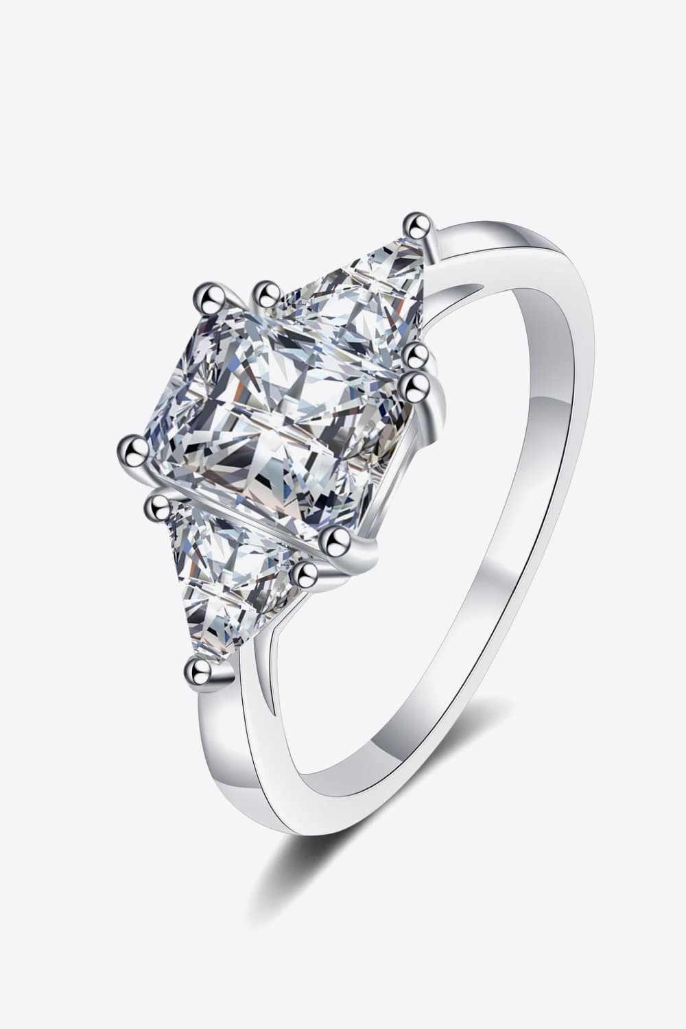 Silver trilogy ring with a large square-cut center stone and two smaller triangular stones.
