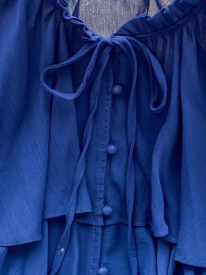 Blue chiffon blouse with tiered ruffles, button front, and bow tie neckline.