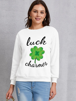 White sweatshirt with a green four-leaf clover graphic and "luck charmer" text.