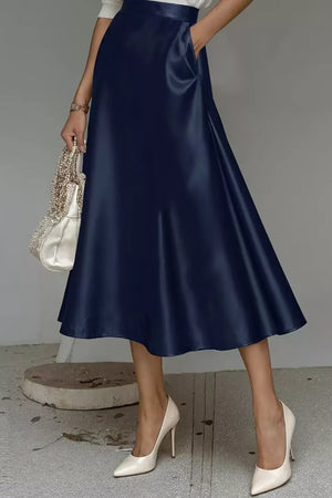Navy midi skirt with a-line cut and hidden pockets, shown with white heels.