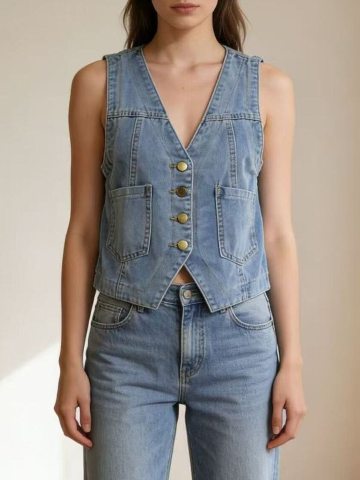 Light blue denim button-down vest with brass buttons and cropped length
