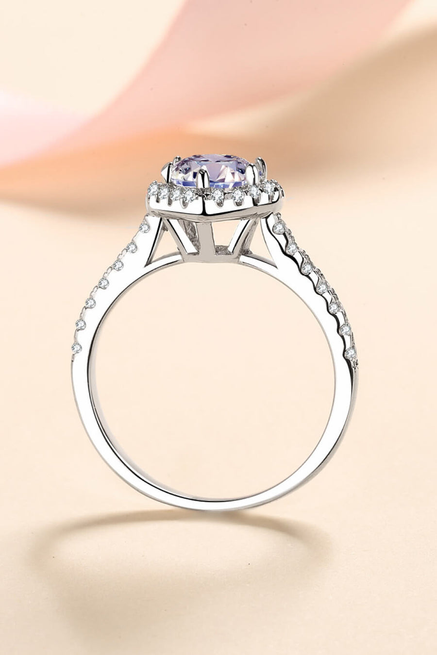 Silver ring with a heart-cut diamond halo and pavé band.