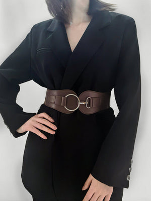 Brown cincher belt with silver buckle detail, worn over a black blazer.
