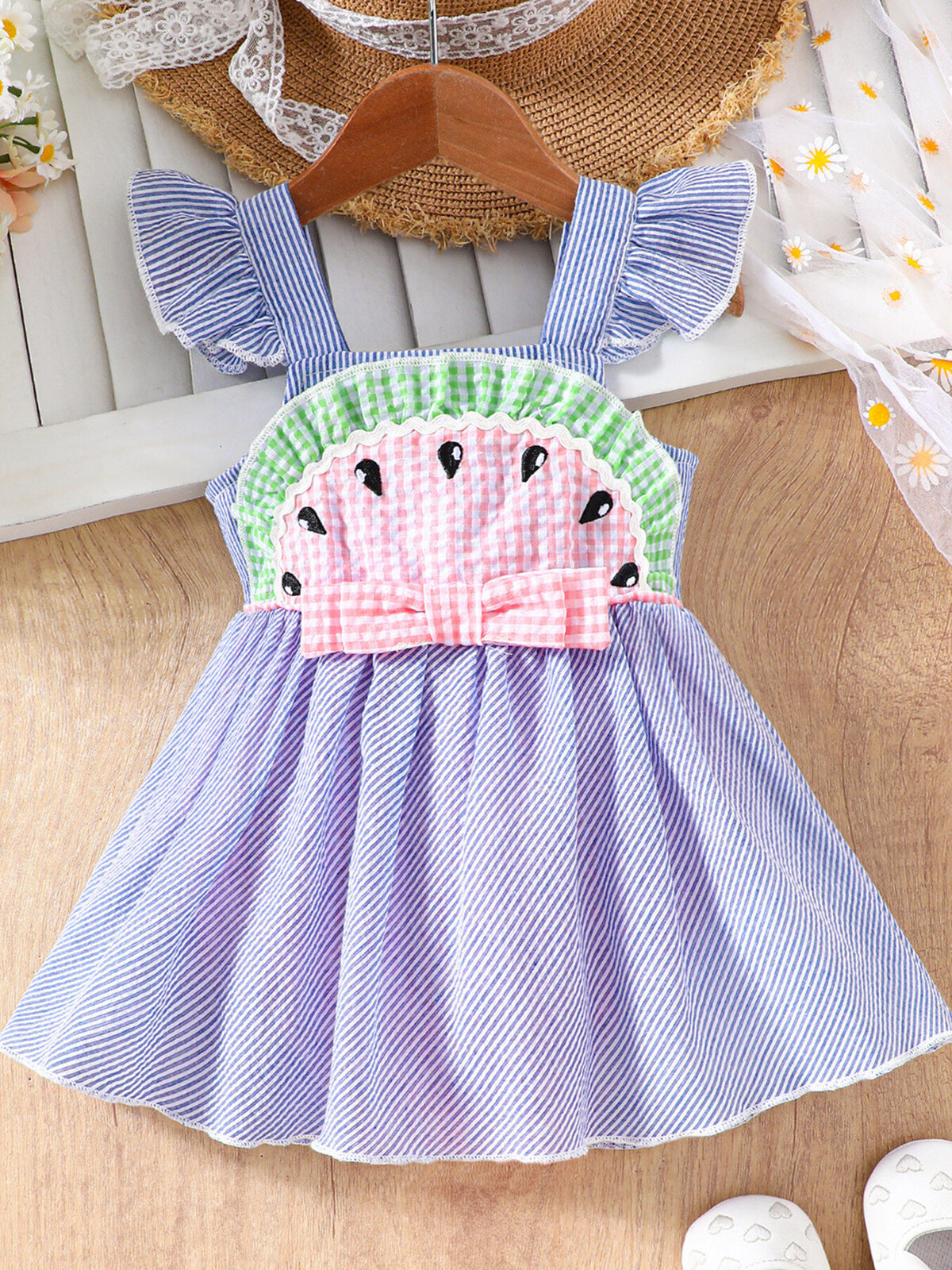 Baby dress with watermelon applique, ruffle sleeves, pink bow, and blue stripes.