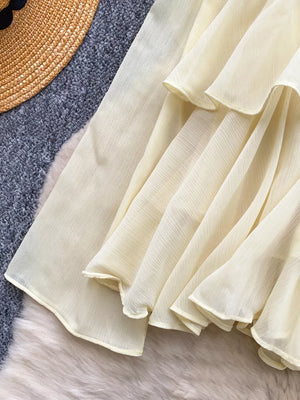 Yellow chiffon blouse with tiered ruffled details and a flowing hem.