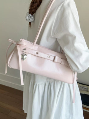 Chic pink PU leather shoulder bag with heart charm and bow detail.